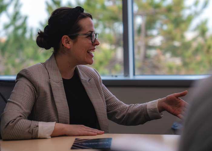Woman speaking with a big smile at a meeting